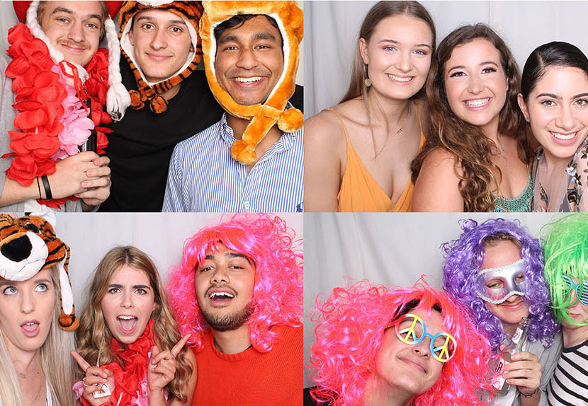 Guests having fun in the photo booth with wigs, hats and leis